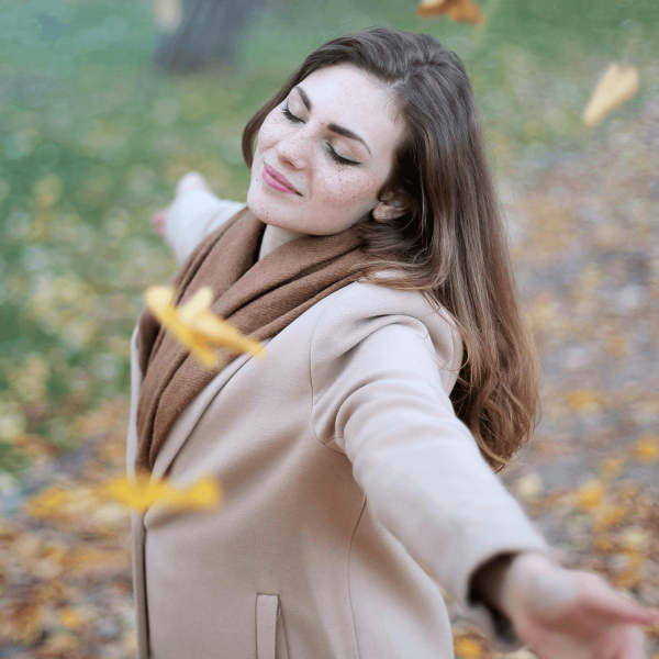 Femme dansant dans les feuilles d'automne