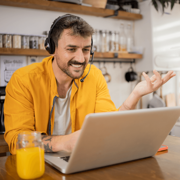 Homme discutant au téléphone devant un ordinateur portable