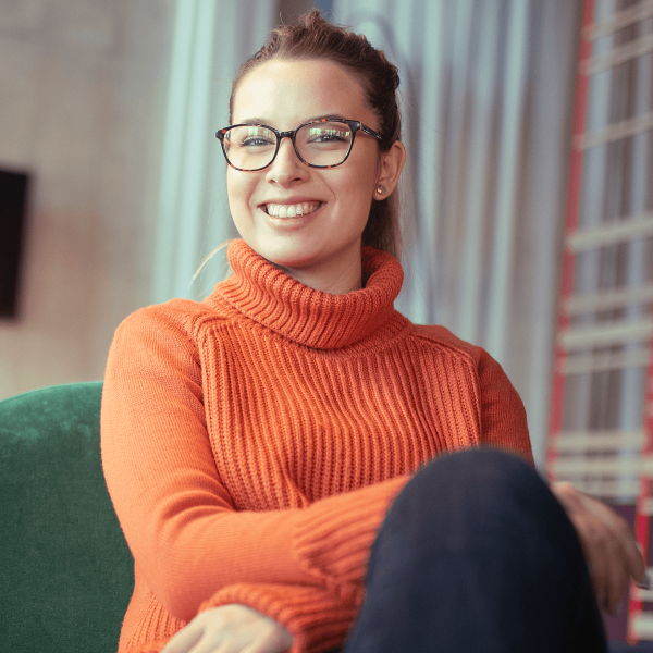Femme portant des lunettes assise dans son salon