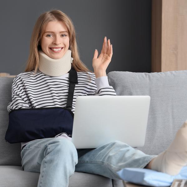 Personne sur canapé bras en écharpe et pied platré sur la table basse