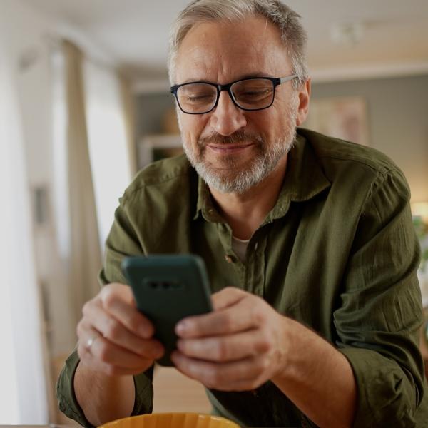 Homme 60 ans consultant son smartphone